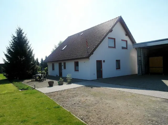 Weißes Einfamilienhaus mit rotem Dach, Hof und Garage