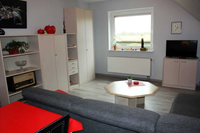 Wohnraum mit Sofa, Couchtisch und Fernseher