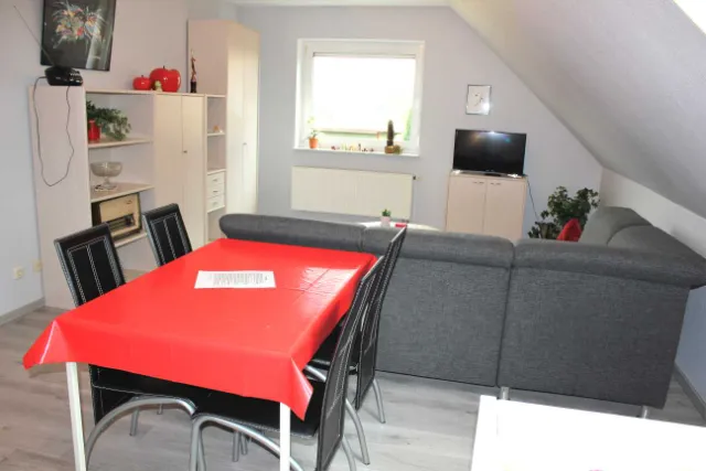 Esstisch mit roter Tischdecke und Stühlen
