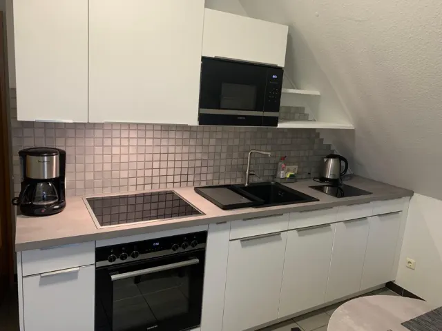 Moderne weiße Küchenzeile mit Backofen und Kochfeld