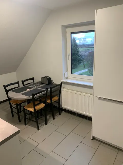 Kleiner Esstisch mit Stühlen am Küchenfenster